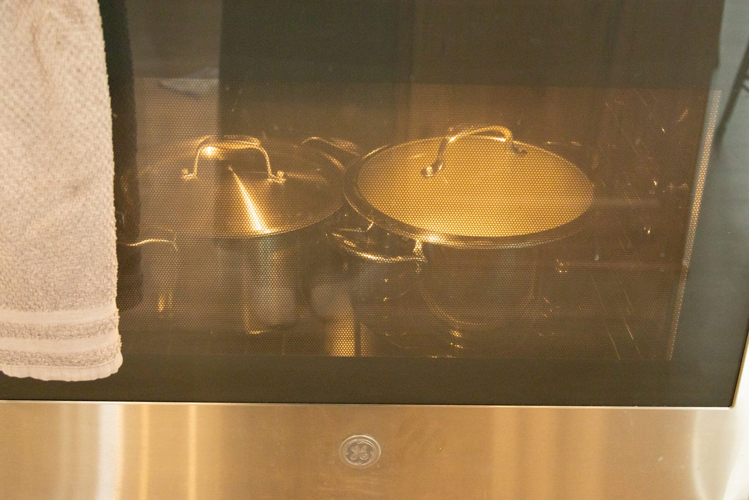 the two pots of yogurt in the oven with the light on