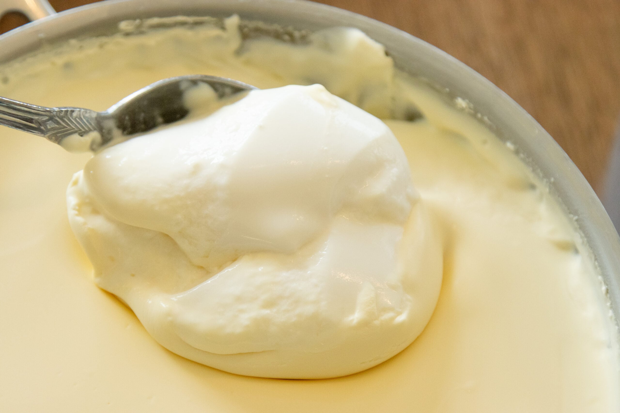 scooping some freshly made yogurt from a bowl