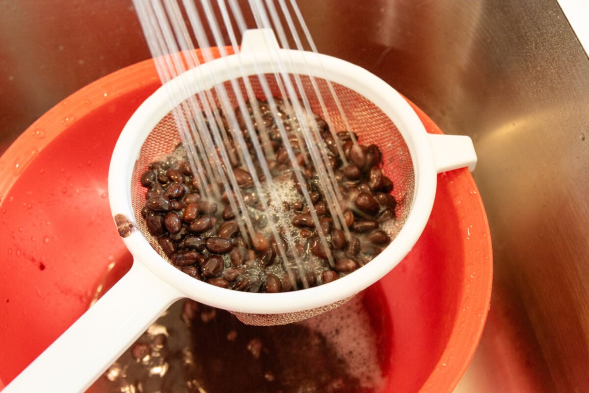 rinsing the beans in a strainer