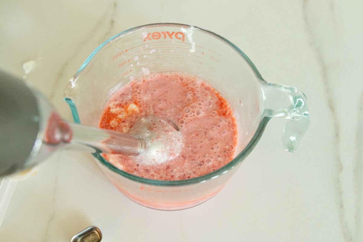 blending the popsicle ingredients in a bowl