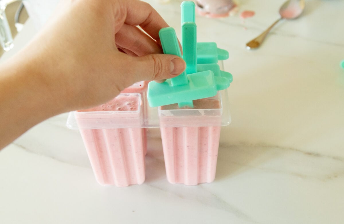 putting the sticks onto the filled molds