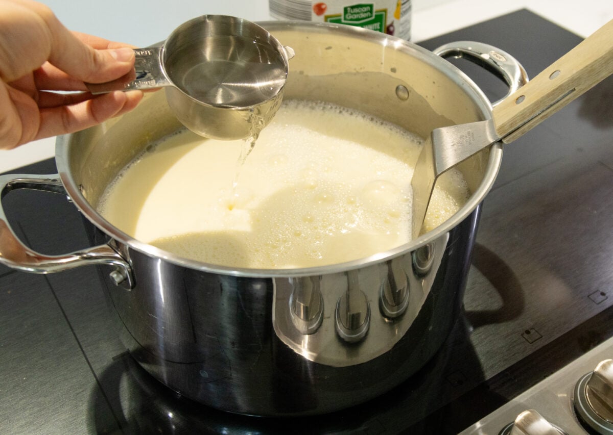 pouring in the vinegar into the milk