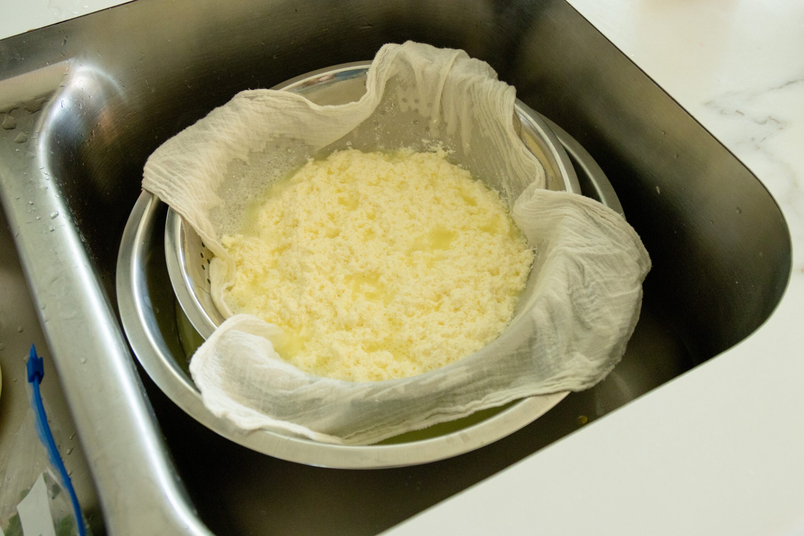 the cheese curds straining in a colander