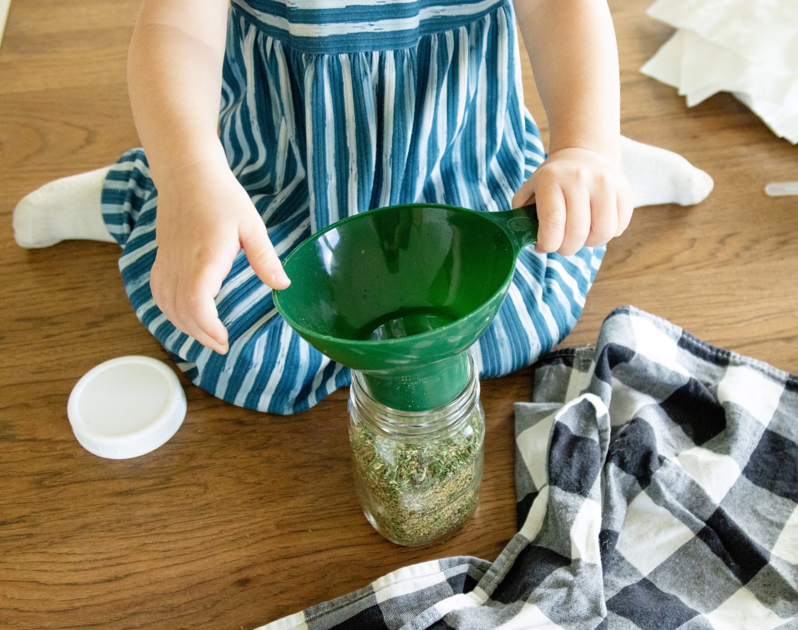 Alethea helping funnel the ingredients into a jar