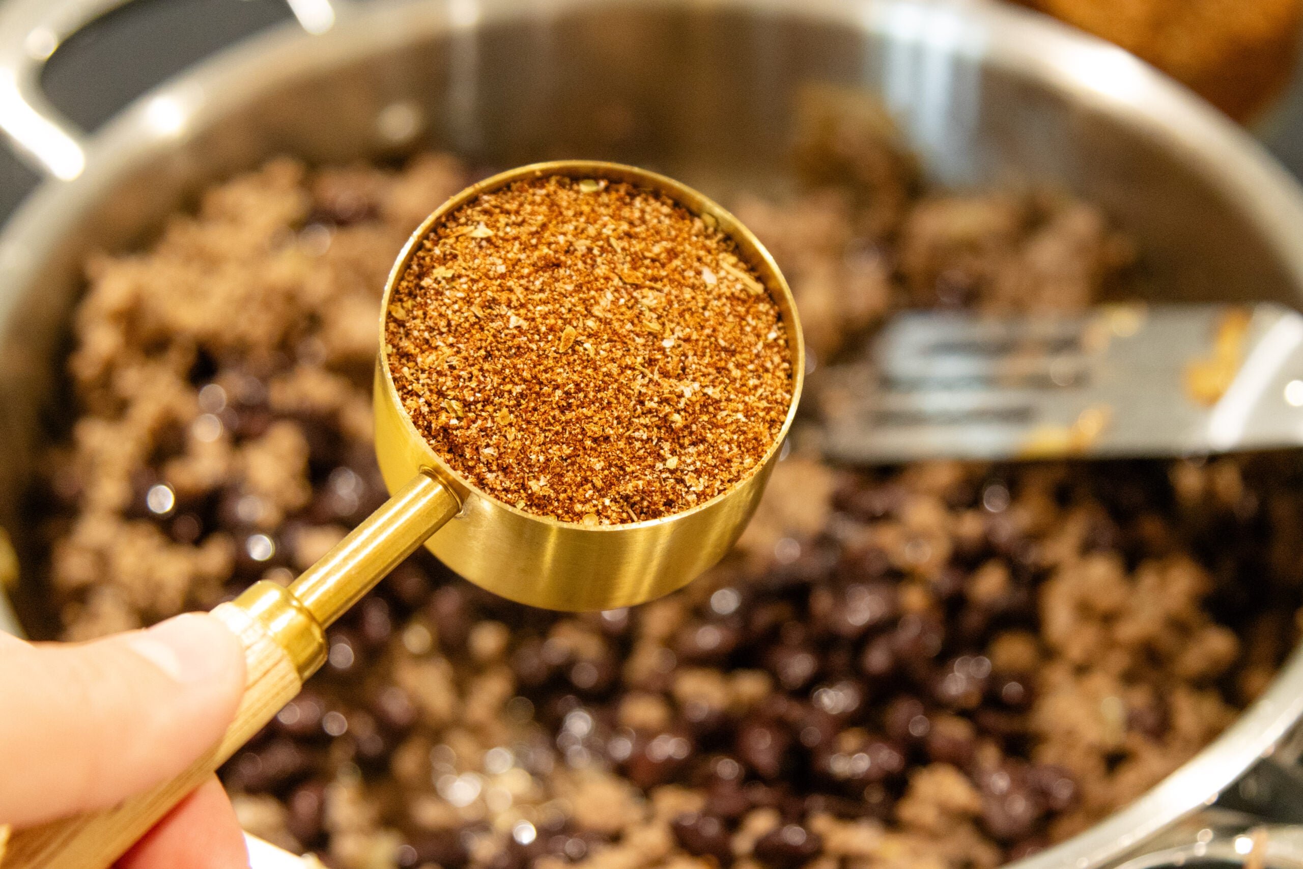 ready to dump taco seasoning into the ground beef
