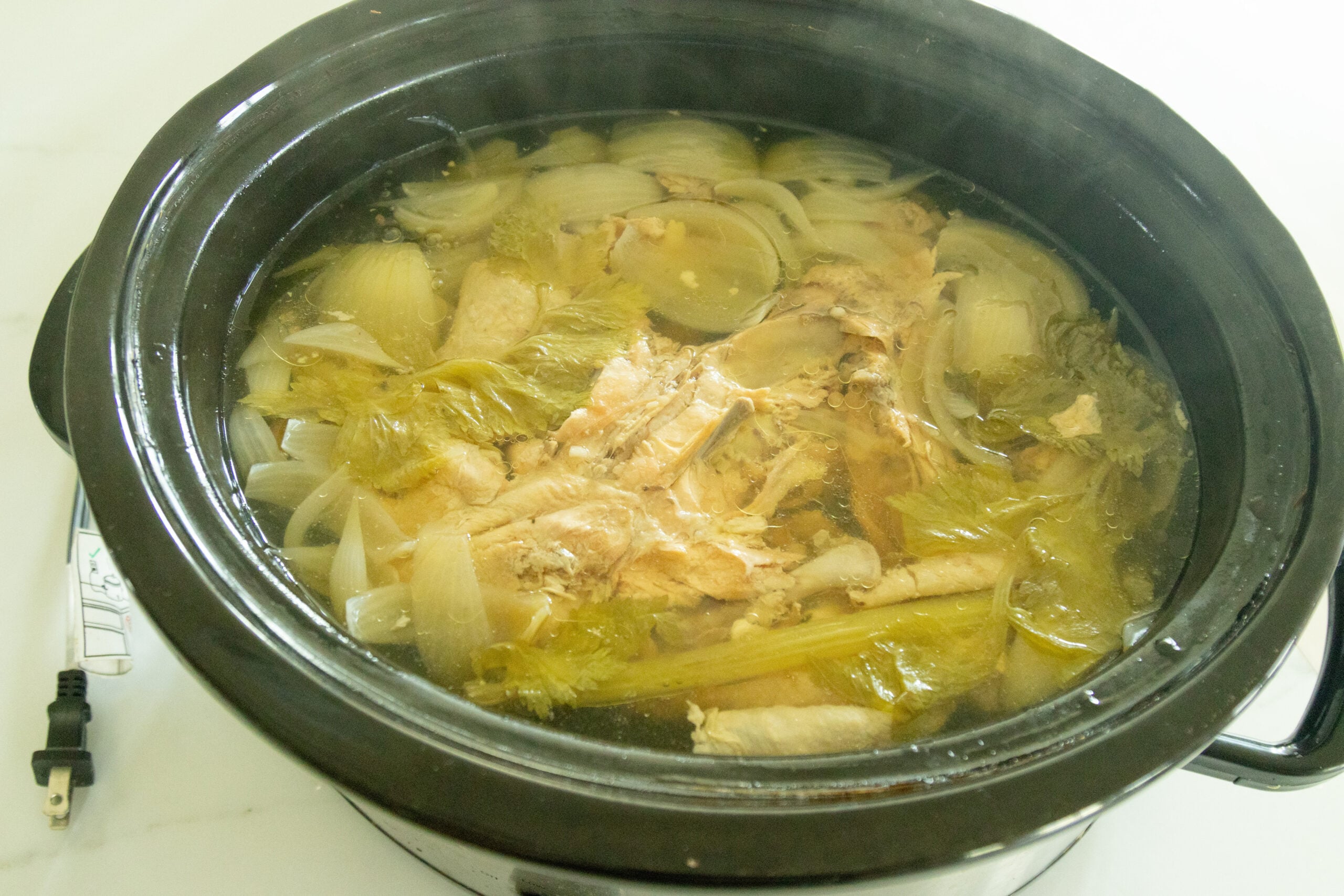 the finished chicken broth still in the crockpot