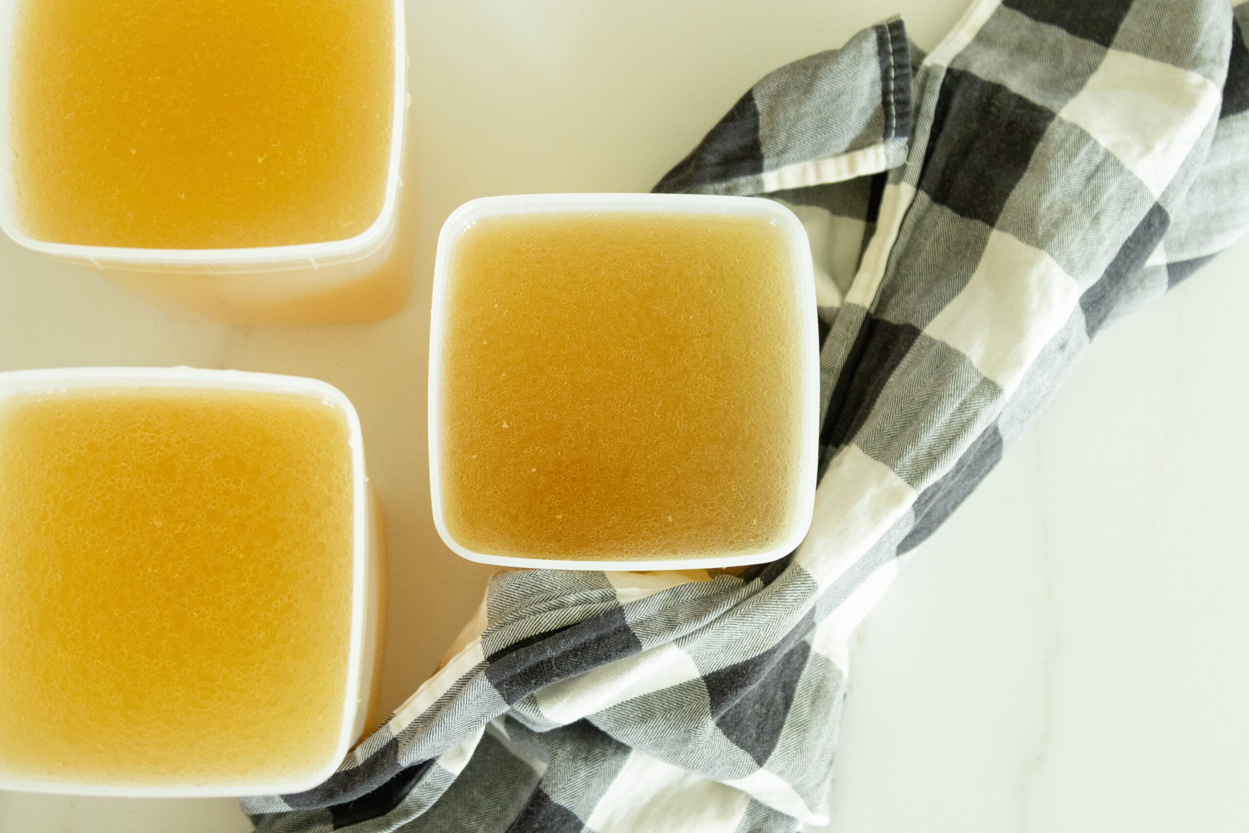 a few containers of bone broth setting on the counter
