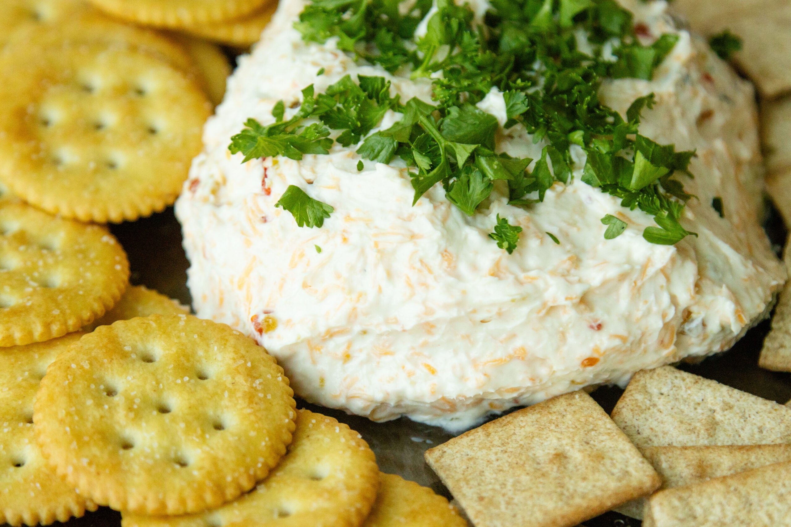 hot pepper jelly cheese ball on a platter with crackers