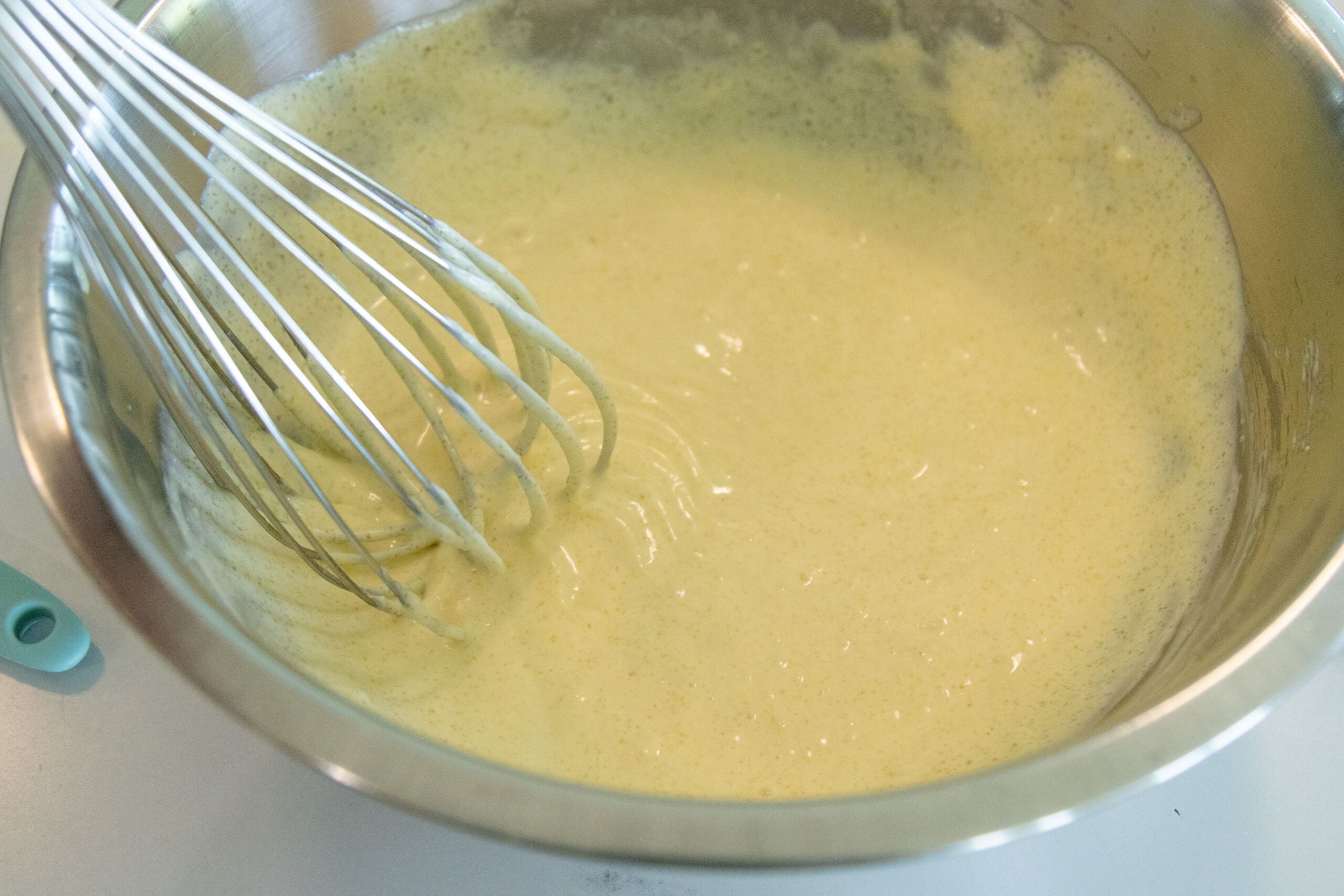 whisking the dressing in the mixing bowl