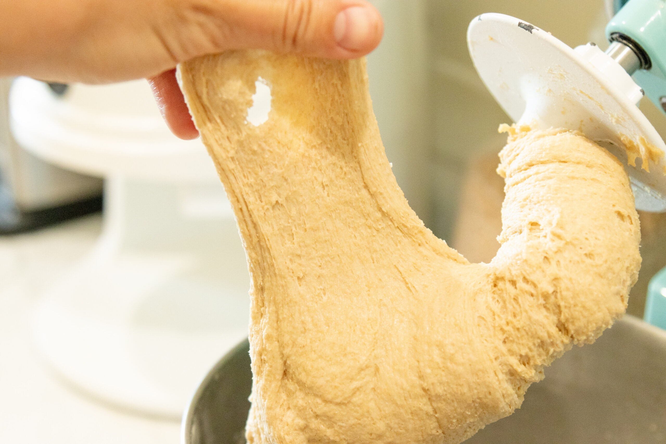 hand stretching the dough, checking for windowpane