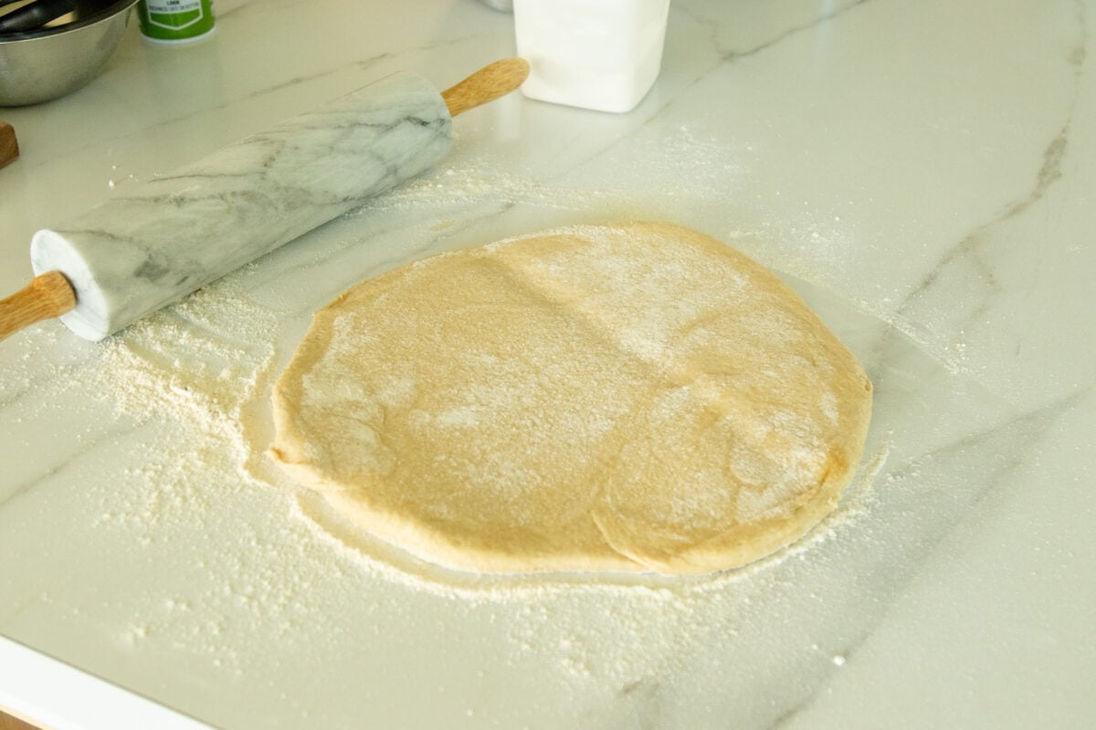 rolling out the pizza dough with the rolling pin