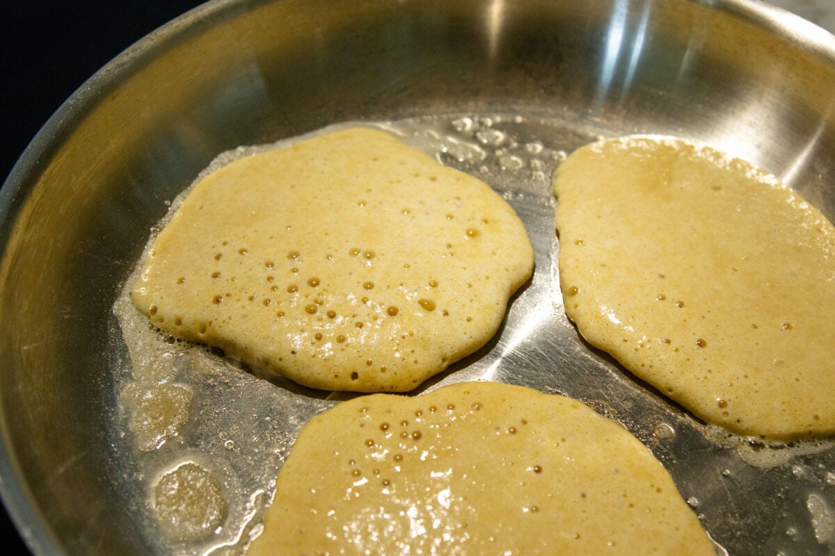 three pancakes frying in a pan