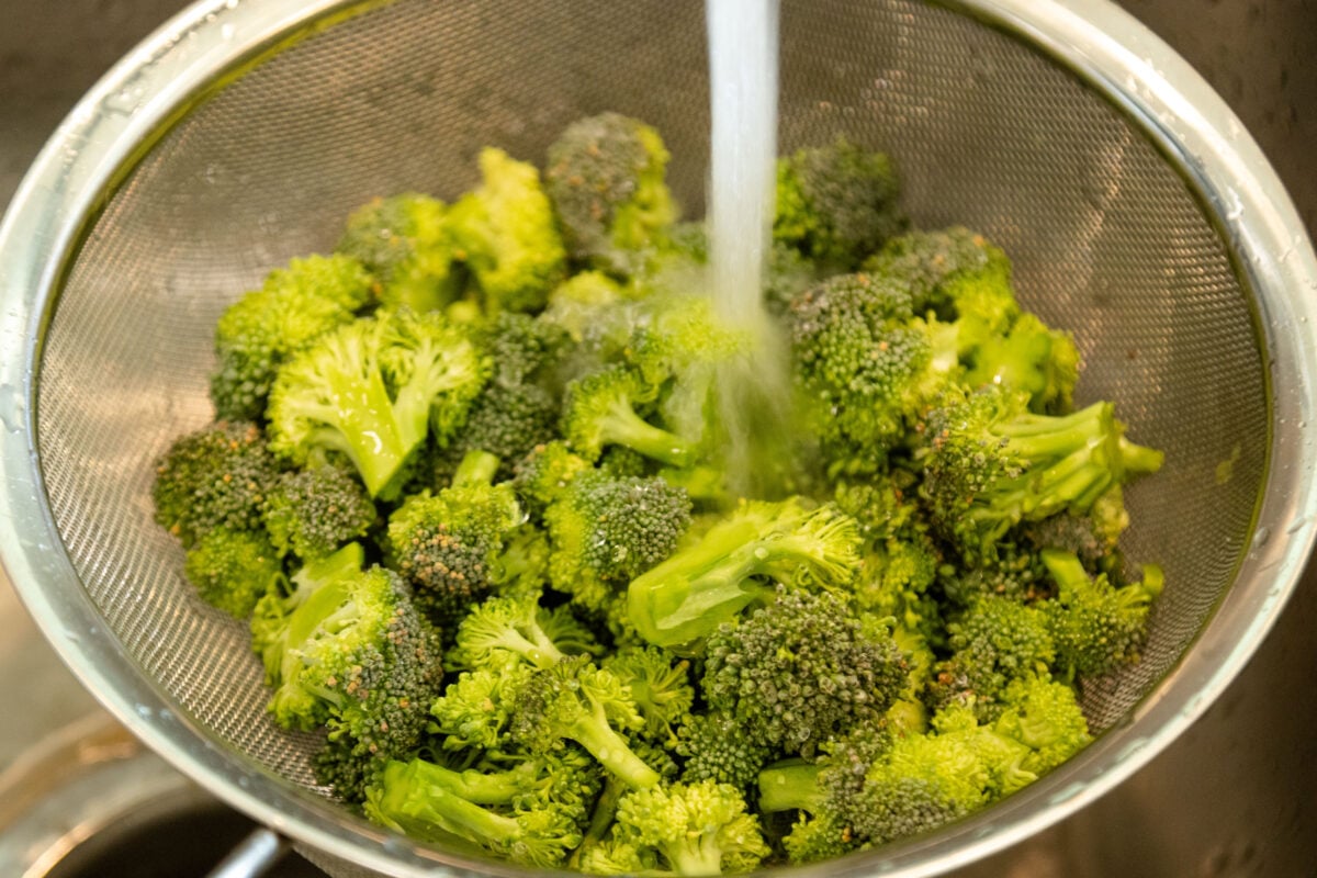 rinsing the broccoli under cold water