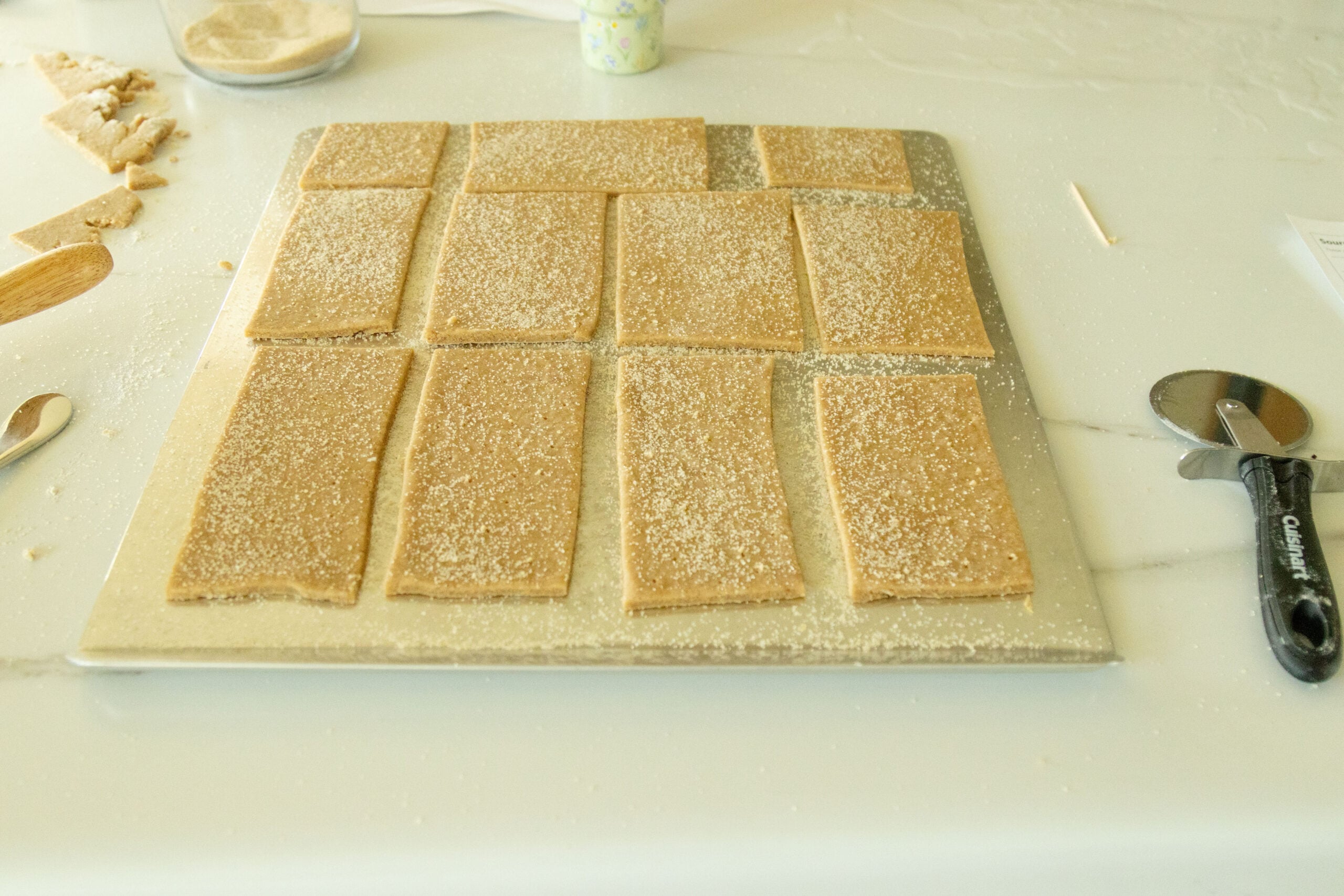 sprinkling sugar and cinnamon on the crackers
