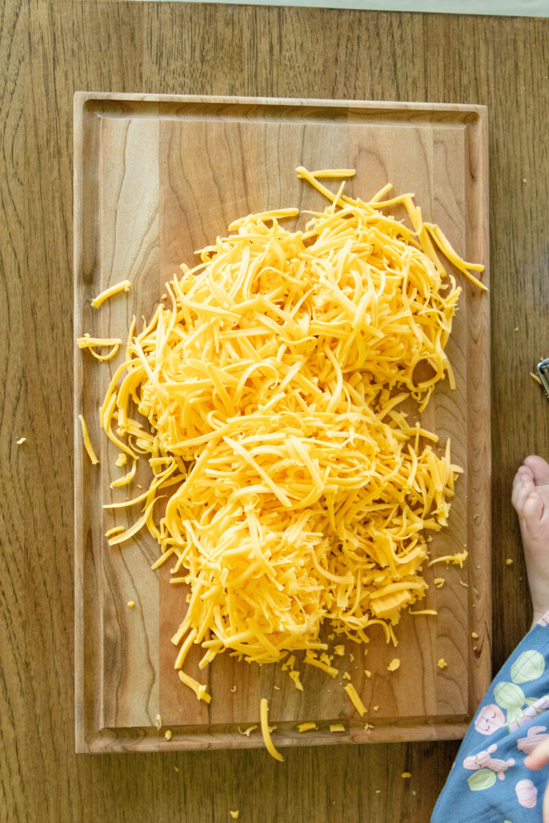 shredded cheddar cheese on a cutting board