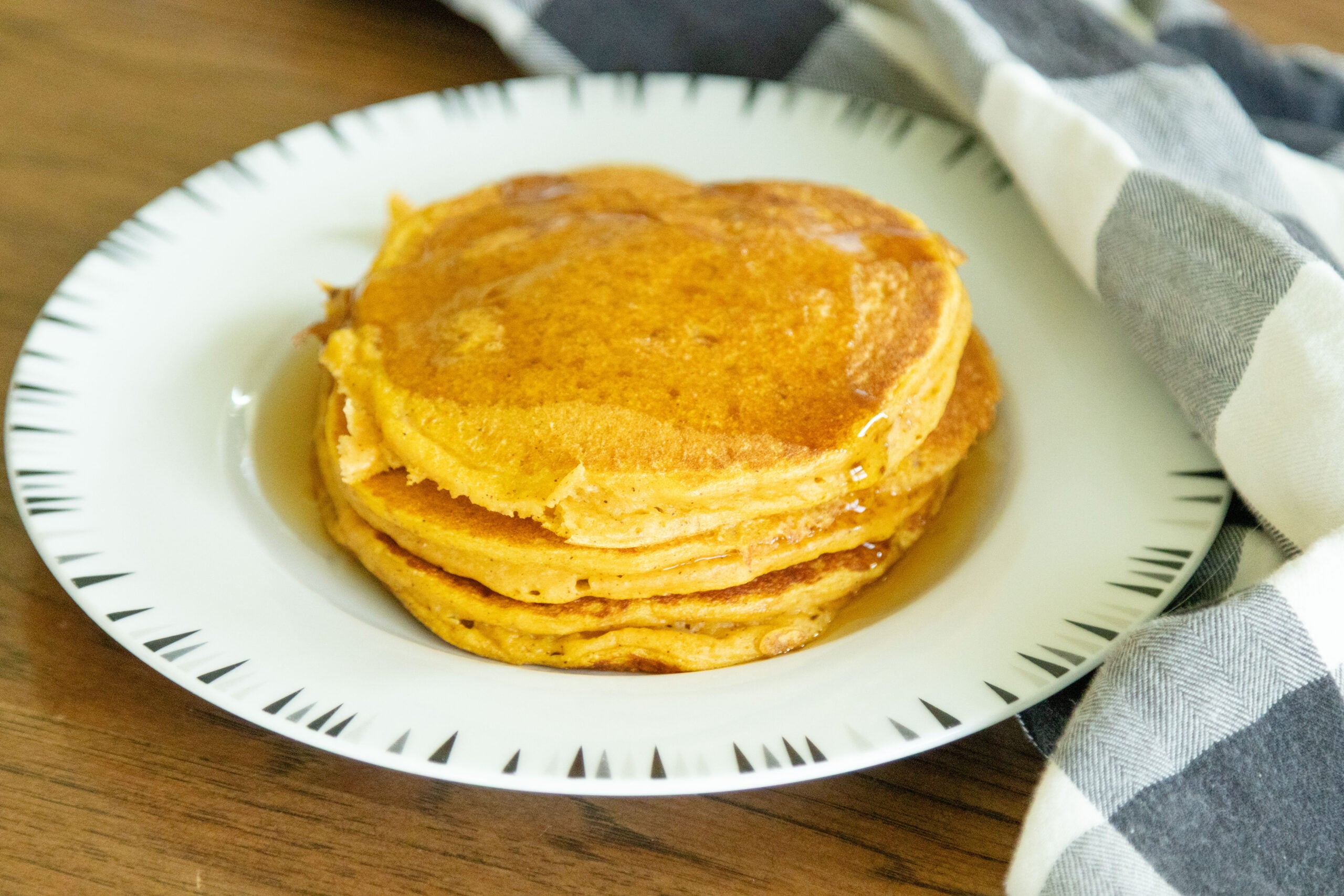 three pancakes stacked on a white plate