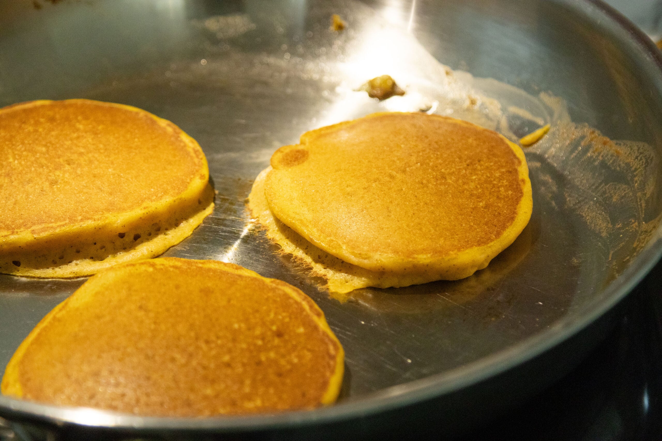 three pancakes in a frying pan