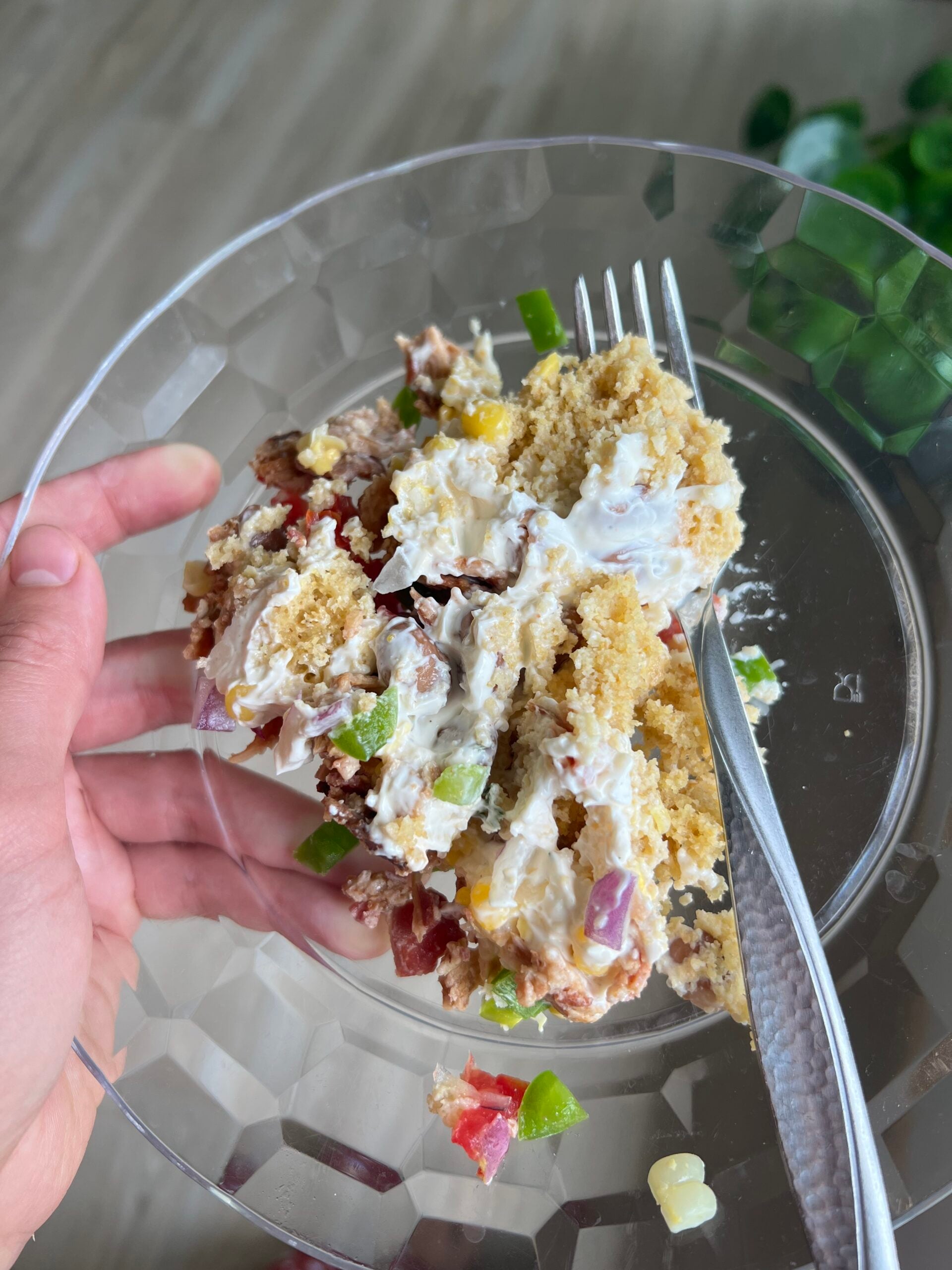 a clear plate with a serving of cornbread salad on it
