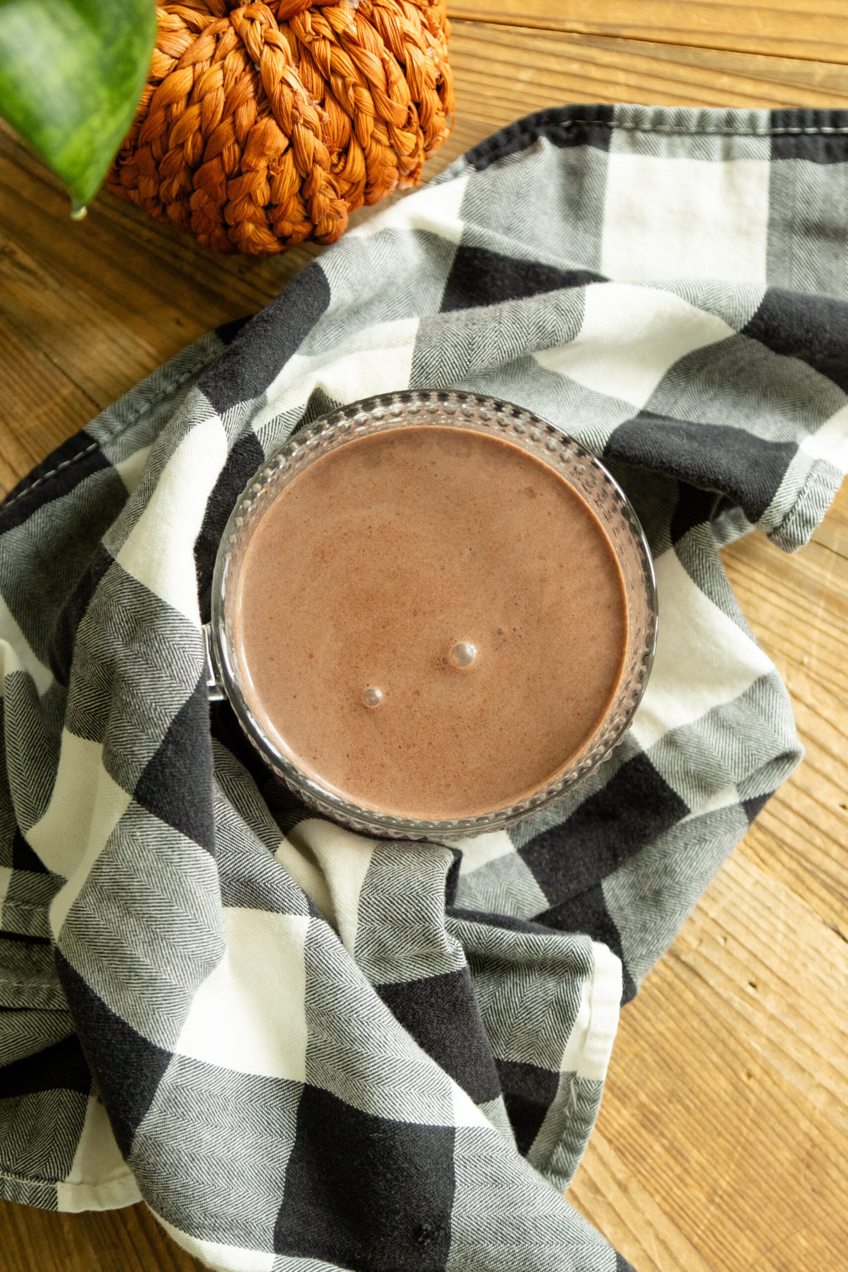 a mug of pumpkin spice hot cocoa on a black and white checkered cloth